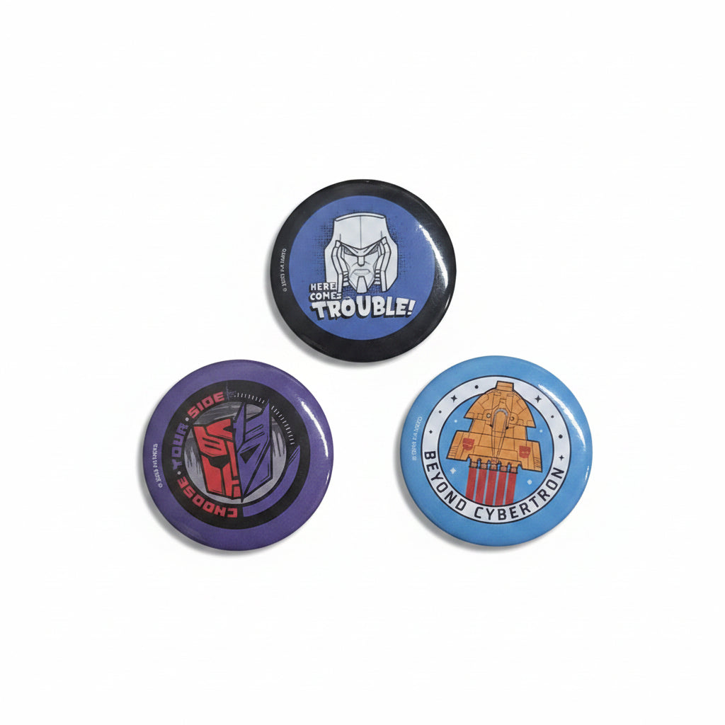 Three buttons with different designs on a wooden surface